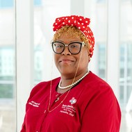 Natasha Rowel, FNP-C, wearing a red Texas Health Care jacket, smiling.
