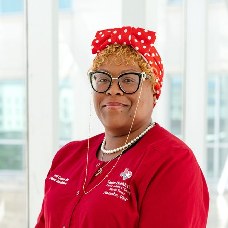Natasha Rowel, FNP-C, wearing a red Texas Health Care jacket, smiling.